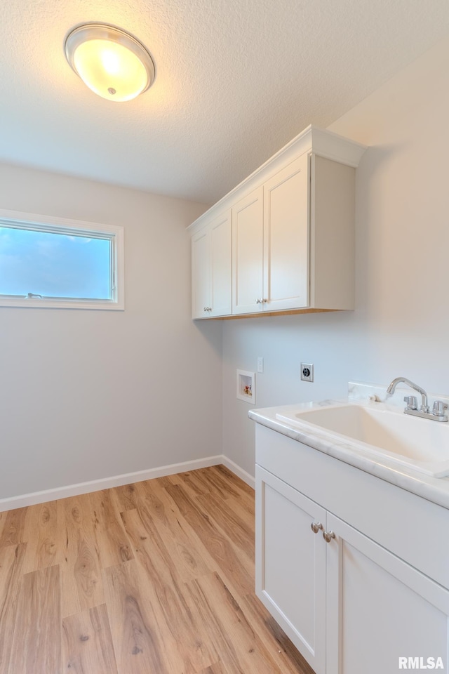941 9th Ave N, Clinton, IA 52732 - laundry room featuring electric dryer hookup, hookup for a washing machine, light wood finished floors, cabinet space, and a textured ceiling