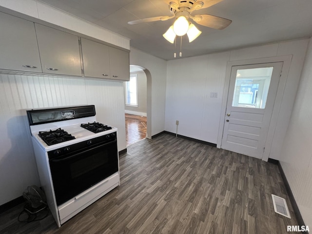 kitchen featuring dark wood-type flooring, ceiling fan, and white gas stove