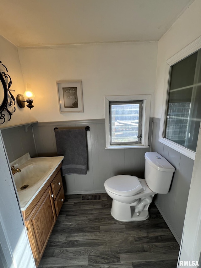 bathroom with hardwood / wood-style floors, vanity, and toilet