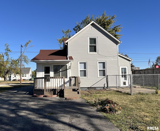 rear view of house featuring a lawn