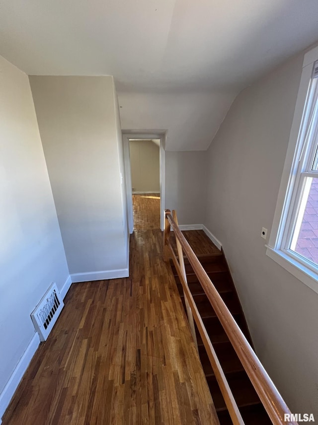 hallway featuring dark wood-type flooring and vaulted ceiling