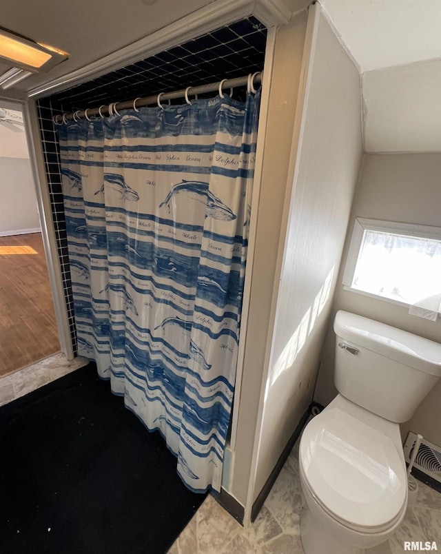 bathroom with a shower with shower curtain, hardwood / wood-style flooring, and toilet