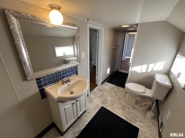 bathroom featuring vanity, toilet, backsplash, and lofted ceiling