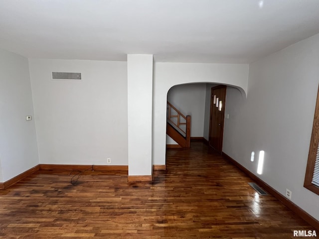 unfurnished room with dark wood-type flooring