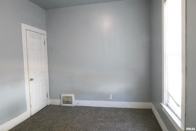 spare room with dark carpet