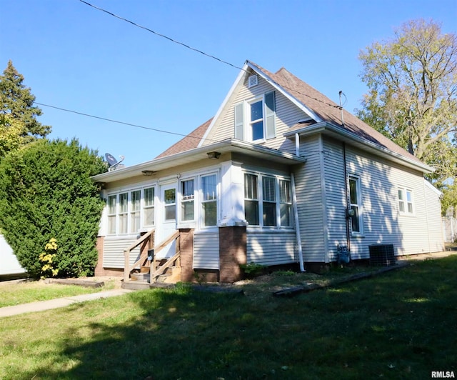 exterior space featuring central AC, a yard, and a sunroom