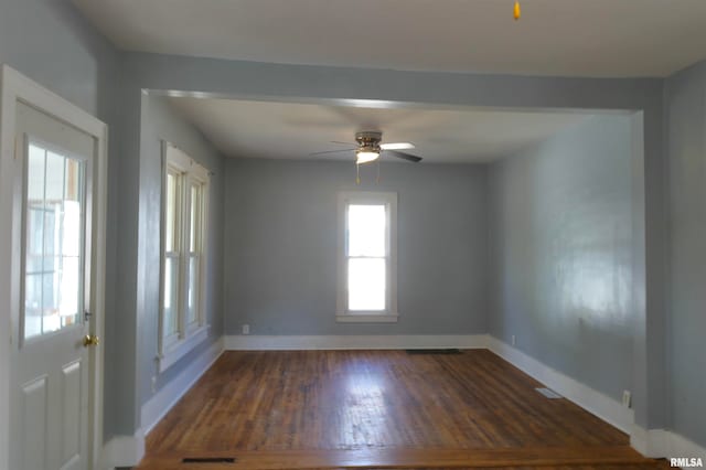 empty room with ceiling fan and dark hardwood / wood-style flooring