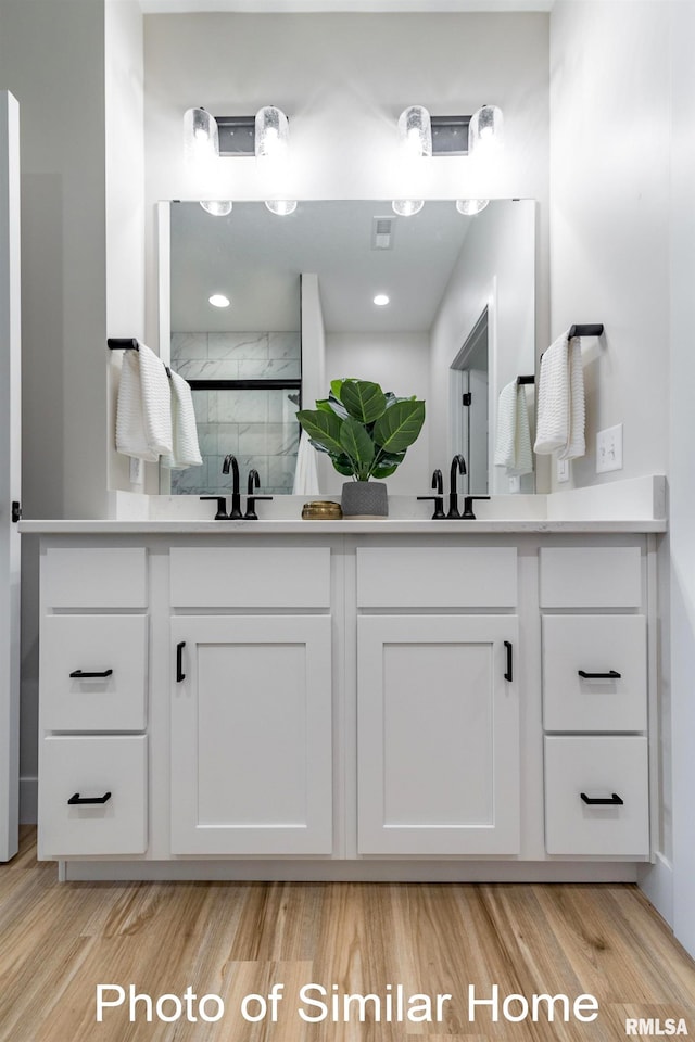 bathroom with vanity, wood-type flooring, and a shower with door