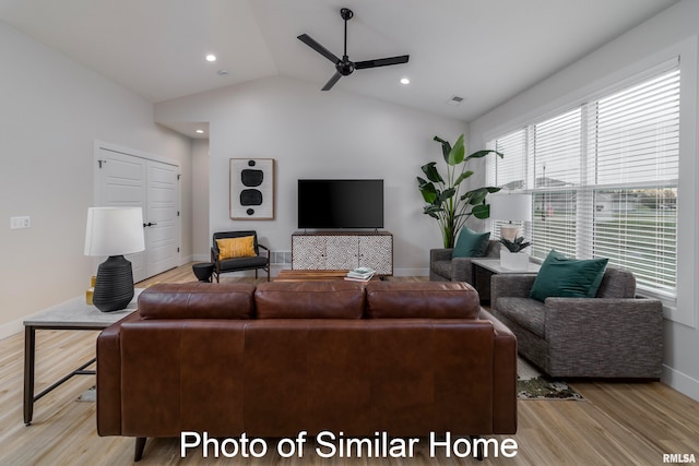 living room with light hardwood / wood-style floors, lofted ceiling, and ceiling fan