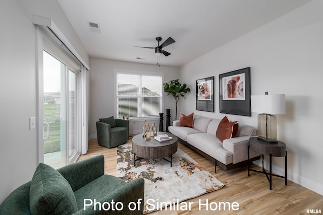 living room featuring light hardwood / wood-style flooring and ceiling fan