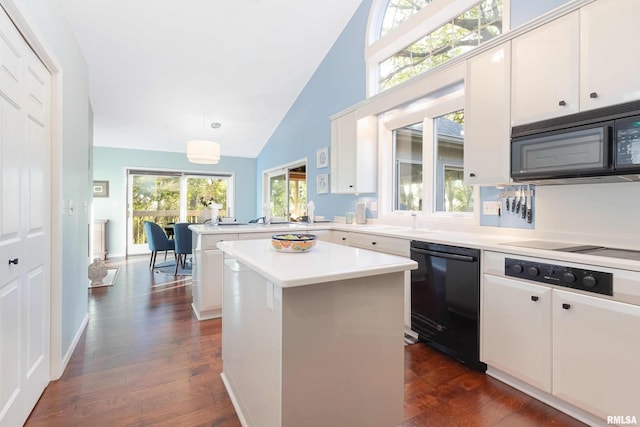 kitchen with black appliances, a kitchen island, dark hardwood / wood-style flooring, hanging light fixtures, and lofted ceiling