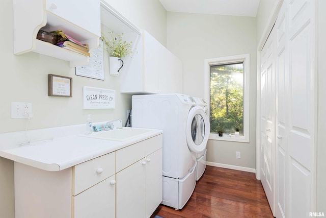 clothes washing area with sink, washer and dryer, dark hardwood / wood-style floors, and cabinets