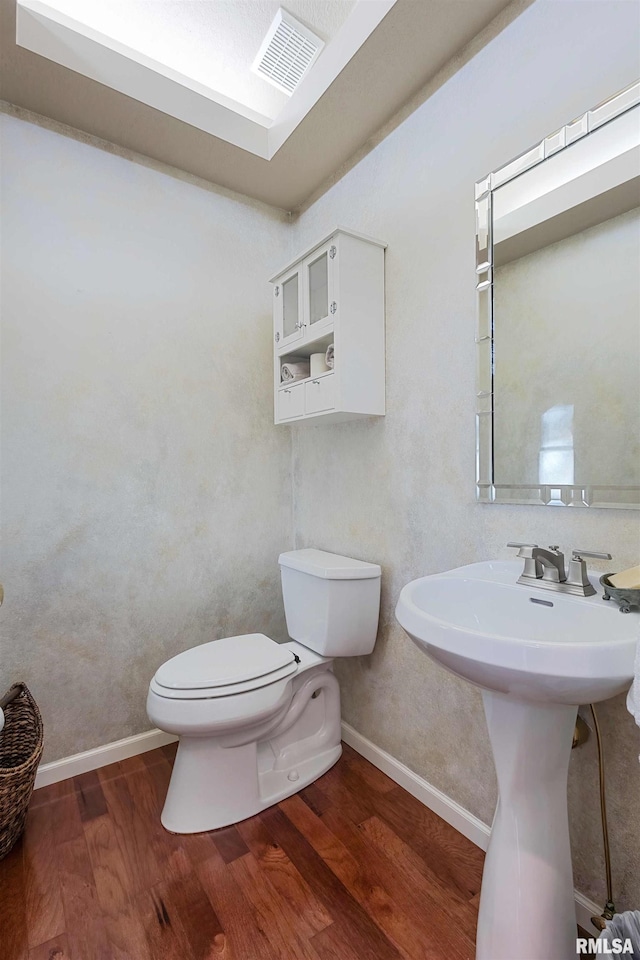 bathroom featuring toilet, hardwood / wood-style flooring, and sink