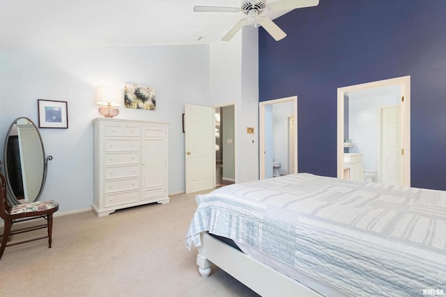 carpeted bedroom featuring ensuite bath, high vaulted ceiling, and ceiling fan