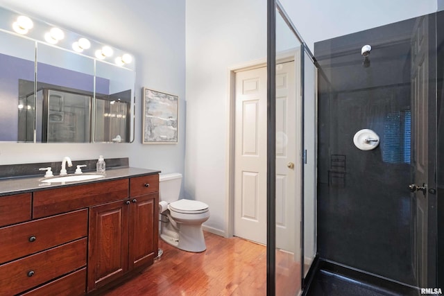 bathroom featuring vanity, walk in shower, hardwood / wood-style flooring, and toilet