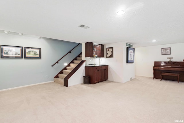 basement with a textured ceiling and light colored carpet