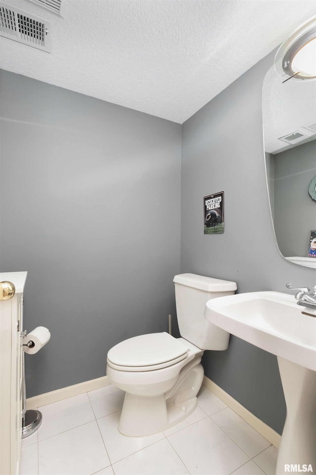 bathroom with tile patterned floors, a textured ceiling, and toilet