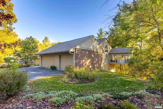 view of side of property with a garage and a lawn