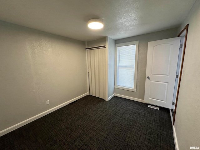 unfurnished bedroom with dark colored carpet