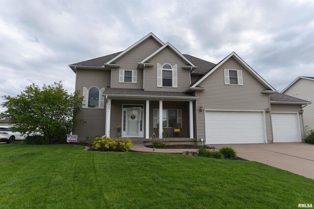 view of front of home with a porch, a front lawn, and a garage