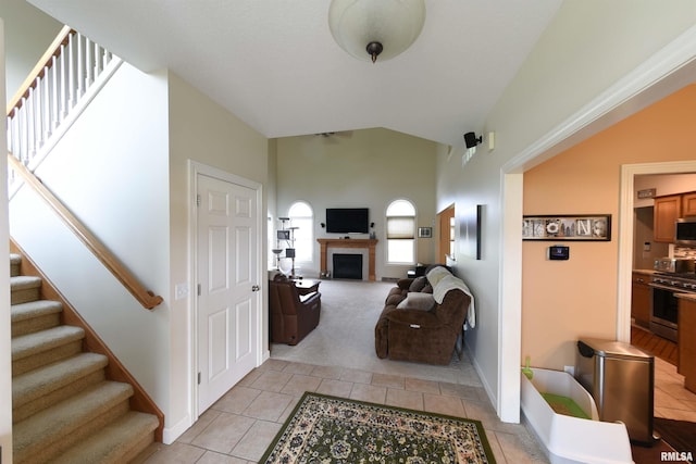 hall featuring light tile patterned floors and lofted ceiling