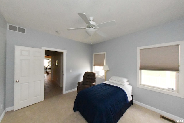 carpeted bedroom featuring multiple windows and ceiling fan