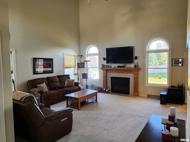 carpeted living room featuring a high ceiling and a tile fireplace