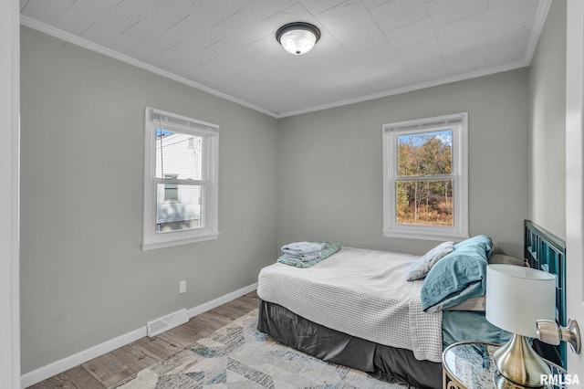 bedroom featuring crown molding and light wood-type flooring