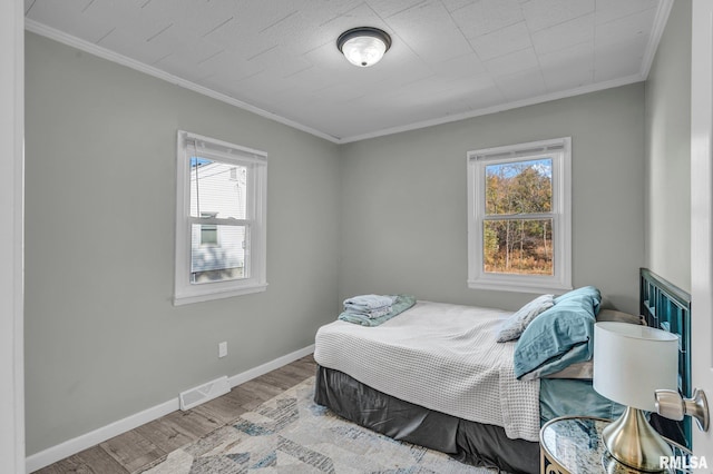 906 28 1/2 St, Bettendorf, IA 52722 - bedroom featuring multiple windows, wood finished floors, and ornamental molding
