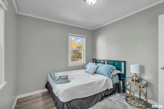 bedroom with crown molding and hardwood / wood-style floors