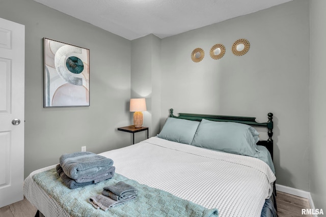 bedroom with a textured ceiling and hardwood / wood-style floors