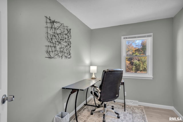 office space featuring light hardwood / wood-style floors and vaulted ceiling