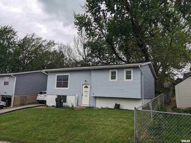 raised ranch with fence and a front lawn