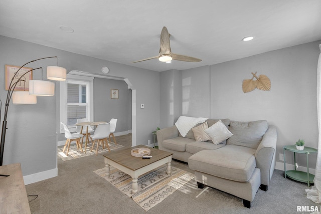 carpeted living room with ceiling fan