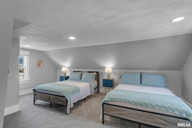 carpeted bedroom with vaulted ceiling and a textured ceiling