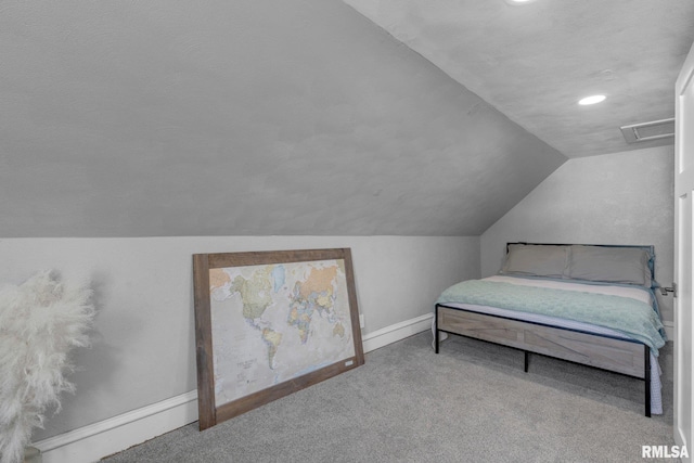 carpeted bedroom with vaulted ceiling and a textured ceiling