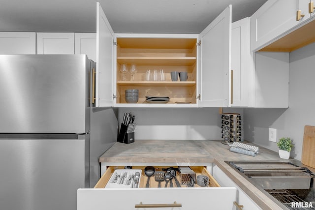 kitchen featuring white cabinets and stainless steel fridge