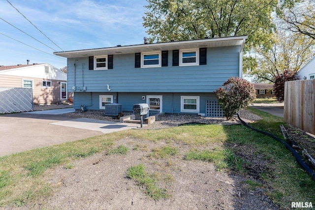 rear view of property with cooling unit and a patio