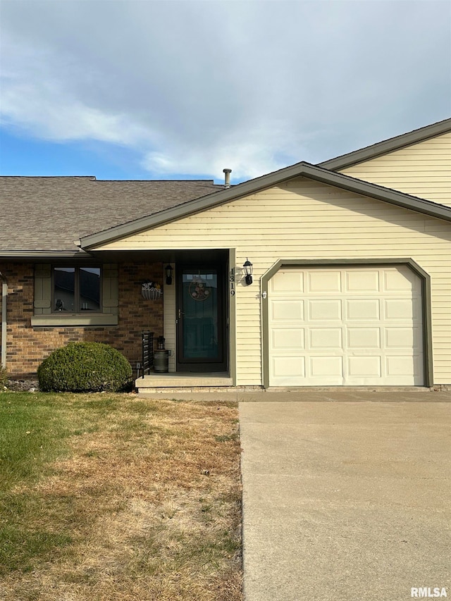 ranch-style home with a front lawn and a garage