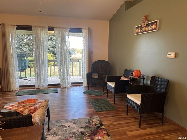 sitting room featuring lofted ceiling, wood finished floors, and a healthy amount of sunlight