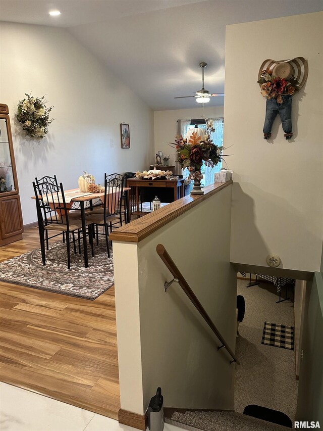 stairway with lofted ceiling, wood finished floors, and ceiling fan