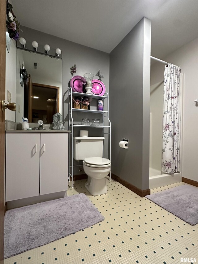 bathroom featuring baseboards, toilet, tile patterned floors, and a stall shower