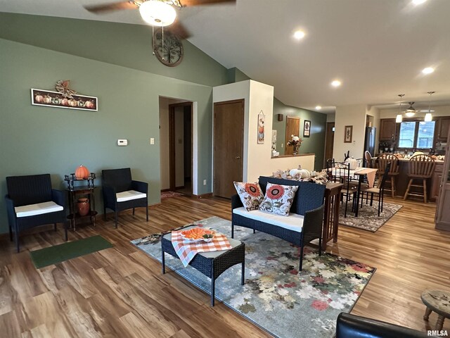 living area with vaulted ceiling, a ceiling fan, light wood finished floors, and recessed lighting
