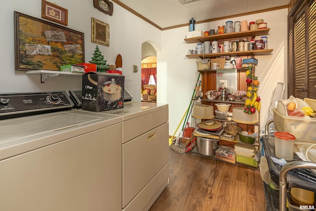 laundry area with ornamental molding, dark wood-type flooring, and washing machine and clothes dryer