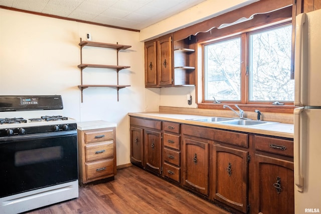 kitchen with ornamental molding, white appliances, sink, and dark wood-type flooring