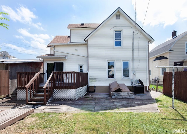 back of house featuring a wooden deck, a patio area, and a lawn