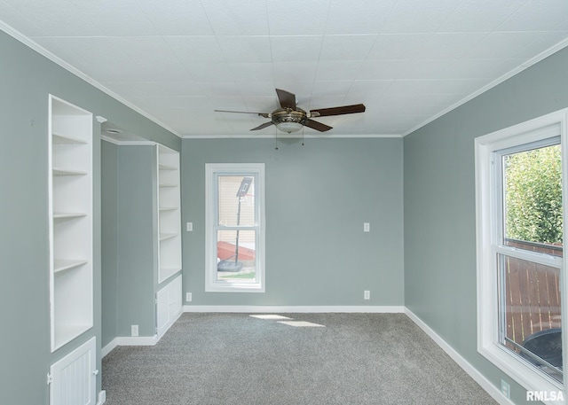 empty room featuring ceiling fan, carpet flooring, and a wealth of natural light