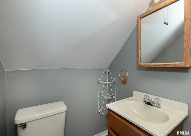 bathroom with vanity, vaulted ceiling, and toilet