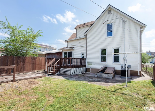 rear view of house featuring a yard and a wooden deck