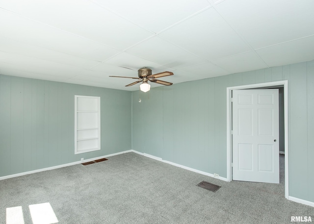 carpeted spare room featuring ceiling fan